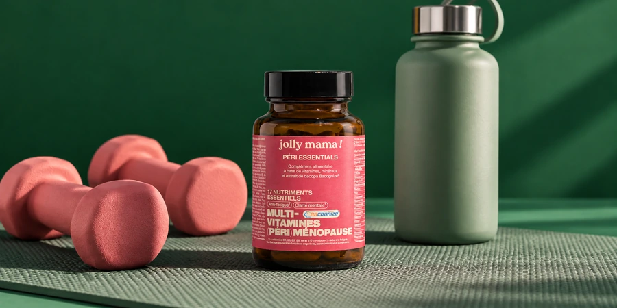 Pot ambré Péri essentials de Jolly Mama à étiquette rose, posé près de deux petits haltères et d’une gourde