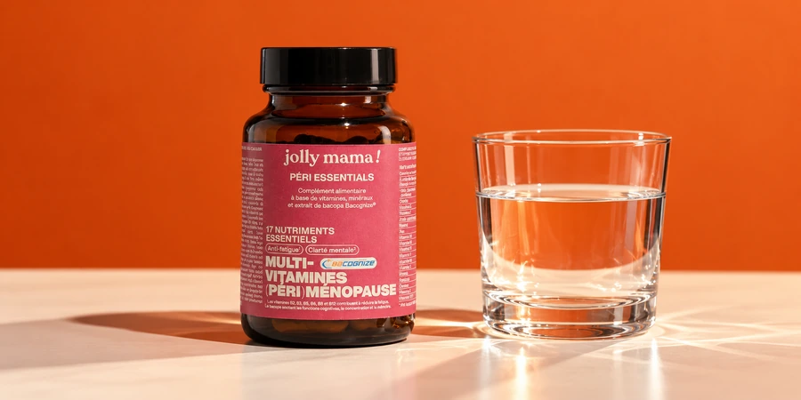 Pot ambré Péri essentials de Jolly Mama à étiquette rose sur une table, à côté d’un verre d’eau